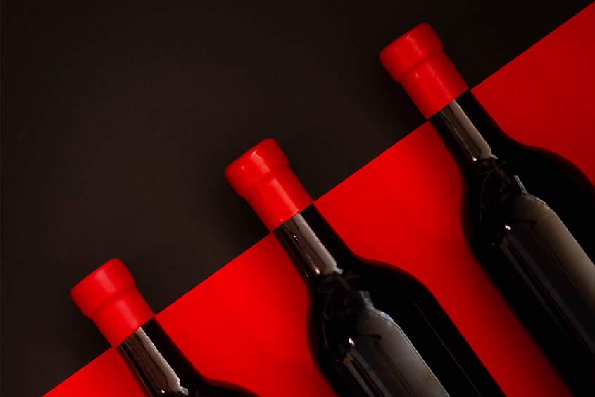 black bottles with red background, and red sealing wax on the neck of the bottles with black background, in diagonal order