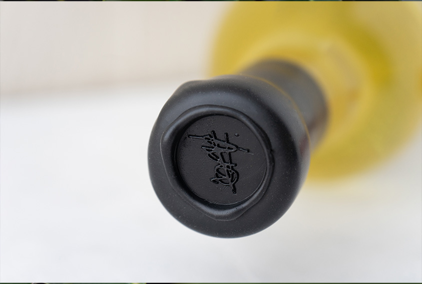 Bottles with black sealing wax on the neck of the bottle and stamped with a scribble logo in the sealing wax