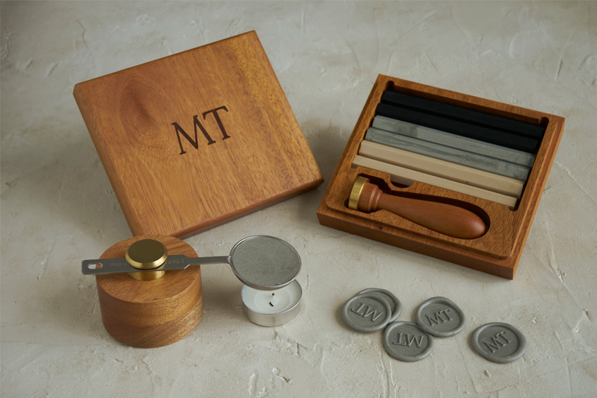 De luxe sealing wax set in engraved wooden box with initials MT, sealing wax bars in black, silver and pearl. Mini melting base and silver medallions