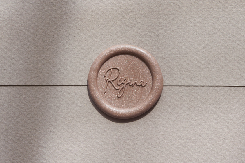 Sealed white envelope with Regina design in golden rose color