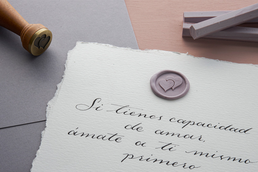 Letter written in calligraphy, with a sealing wax sticker in lavender color of hearts design, lavender sealing wax bars and the seal