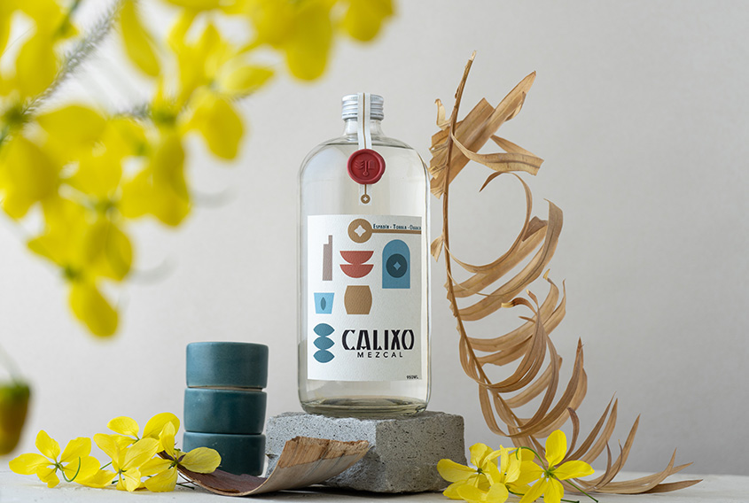 Mezcal bottle with a coral sealing wax sticker with the logo of Calixo Mezcal