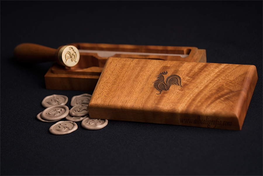 Wooden case with engraved rooster in the center, sealing wax seal with logo of rooster and medallions in golden rose color