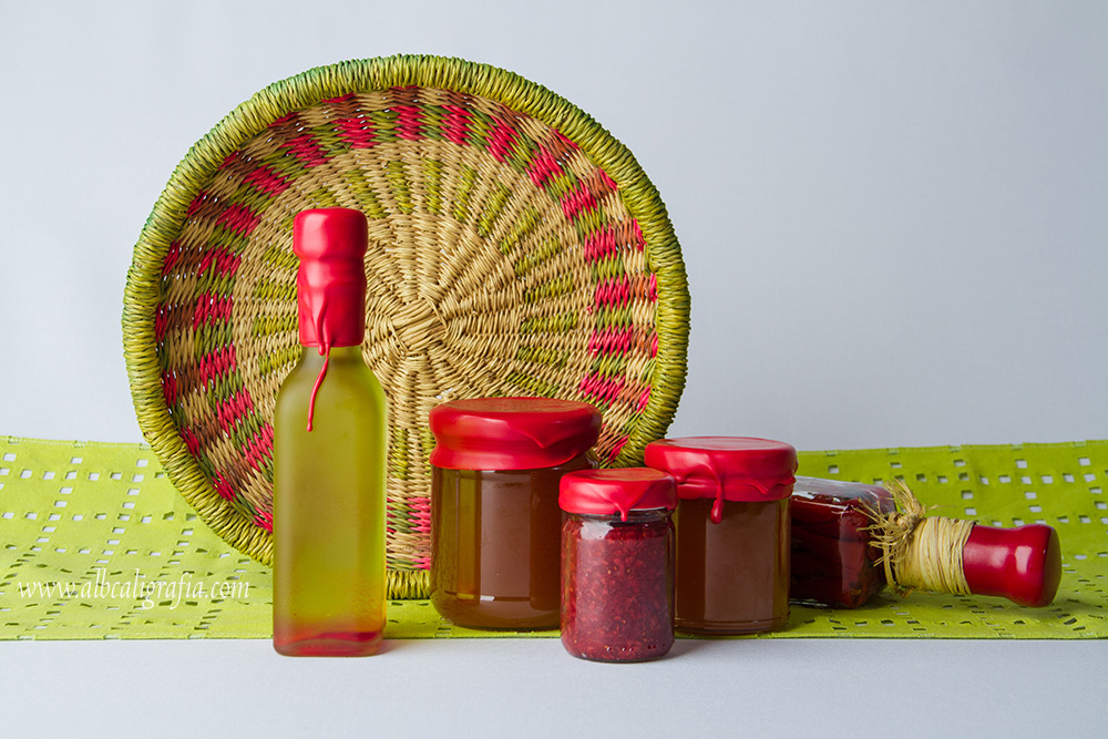 Bottles of oil and canned preserves wax dipping in red color, decoration with a basket of wicker and a green cloth