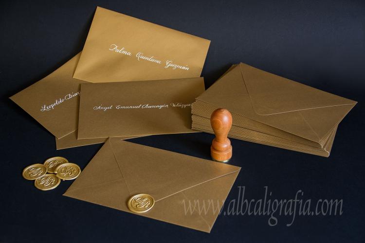 Gold envelopes, labeled in cream color calligraphy and sealed with gold sealing wax stickers