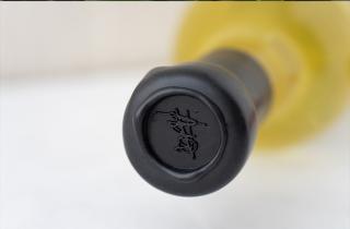 Bottles with black sealing wax on the neck of the bottle and stamped with a scribble logo in the sealing wax