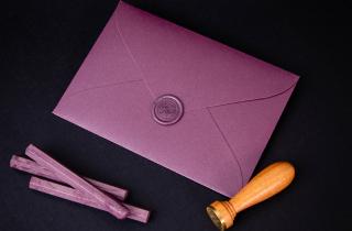 purple envelope with violet sealing wax sticker in celtic knot design, and violet sealing wax sticks