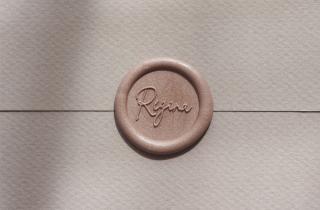 Sealed white envelope with Regina design in golden rose color