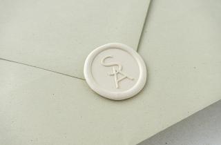 Sealed green envelope with SA initial design in ivory color