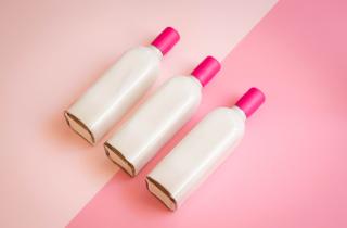white bottle with magenta sealing wax on the neck of the bottle and a bicolor background in two shades of pink